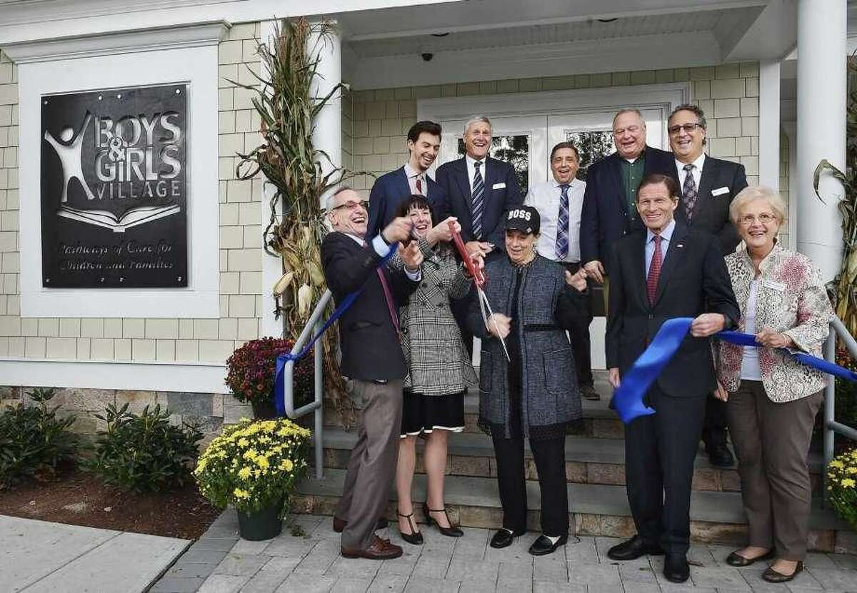 Front row, from left, Dr. Steven M. Kant, president and CEO of Boys & Girls Village; Kimberly Shaunesey; state Department of Children and Families Commissioner Joette Katz; U.S. Sen. Richard Blumenthal; and Carol Smith Harper, chairwoman of the board, with, back row, from left, Ben Florsheim, representing Sen. Christopher Murphy; Gregory Raucci, Bismarck Construction; Gino Pelaccia, facilities manager; John Wicko, architect; and Joseph Tramuta, vice chairman of the board, cut the ribbon for the new program services building at Boys & Girls Village in Milford.