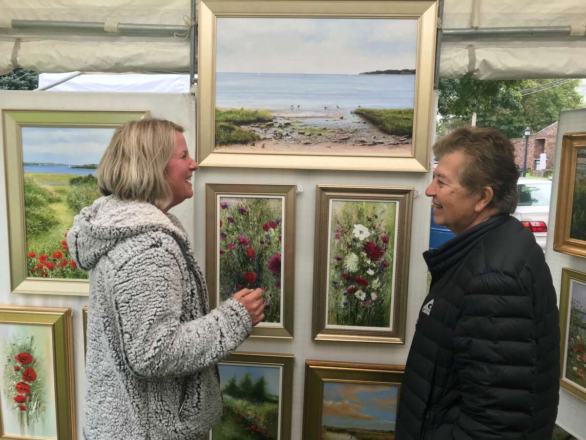 Event organizer Jennifer Csedrik compliments artisan vendor Carlos Rios' work.
