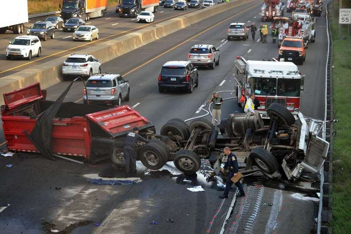 Police investigate the scene of a fatal truck accident that shut down traffic on northbound I-95 north of exit 40 in Milford on Thursday, Nov. 1. The truck had its bed raised and struck the Quarry Road overpass.