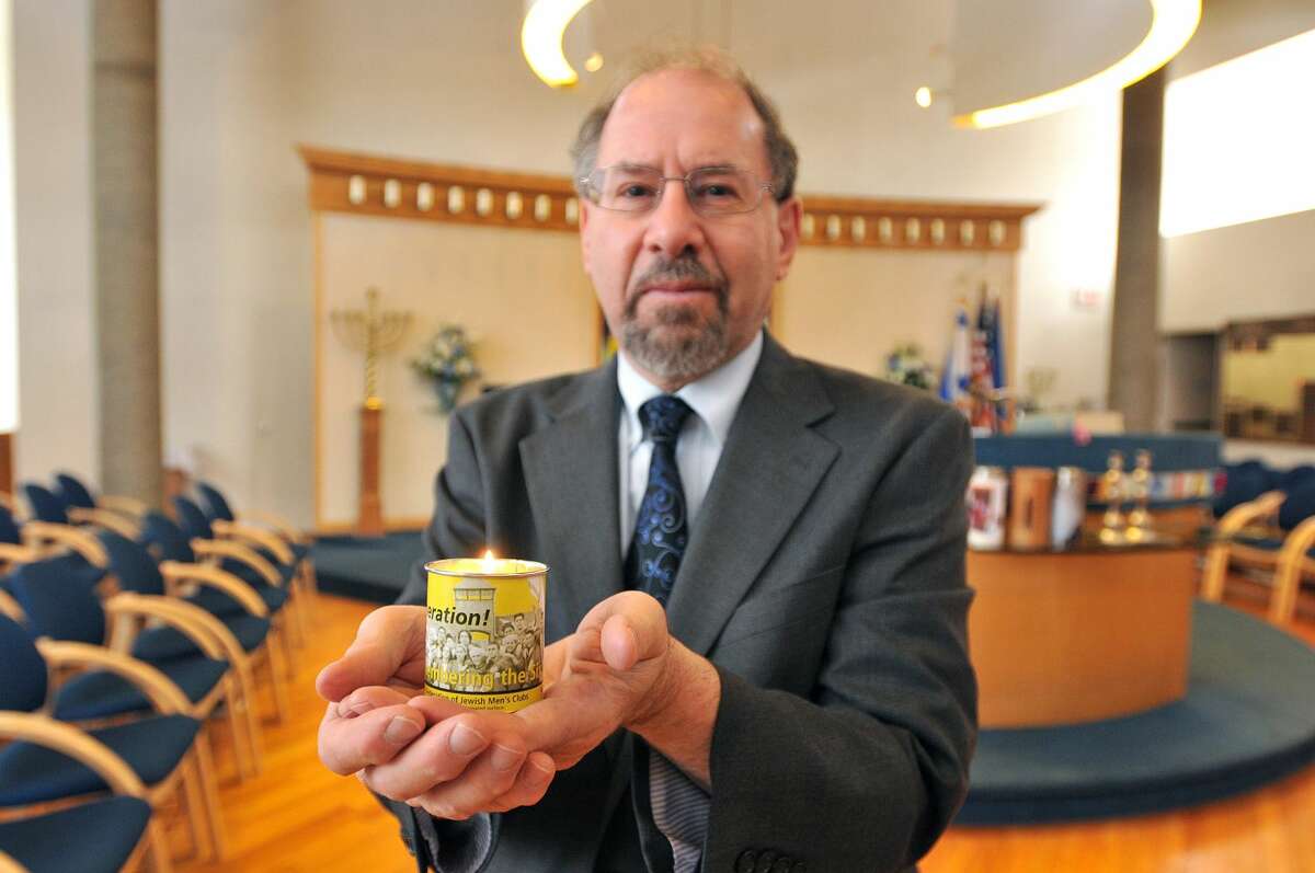Rabbi Alvin Wainhaus of the Or Shalom synagogue holds a Holocaust Remembrance candle.