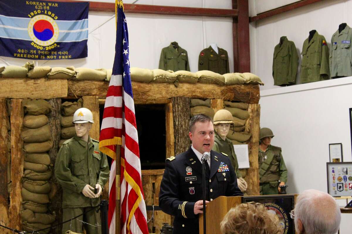 Major Stephen McSweeney addresses the crowd in front of the Korean War display.