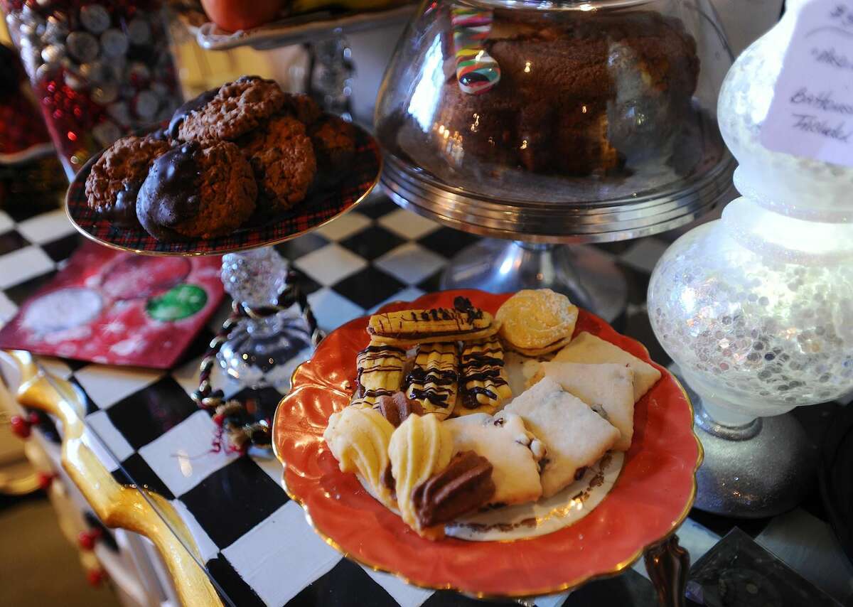 Lynda Kilgore puts out cake, plates of cookies, and coffee for customers at her Miss Dallas' Shop gift store at 16 Higgins Drive in Milford.