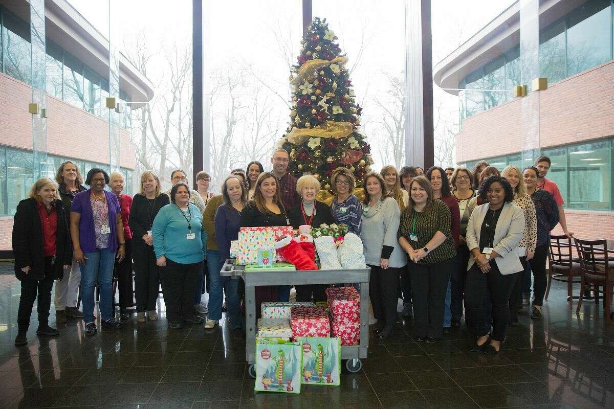 Milford Family Resource Center Manager Peggy Kelly, center, with Subway HQ employees who participated in the Adopt-a-Family program on Dec. 17.
