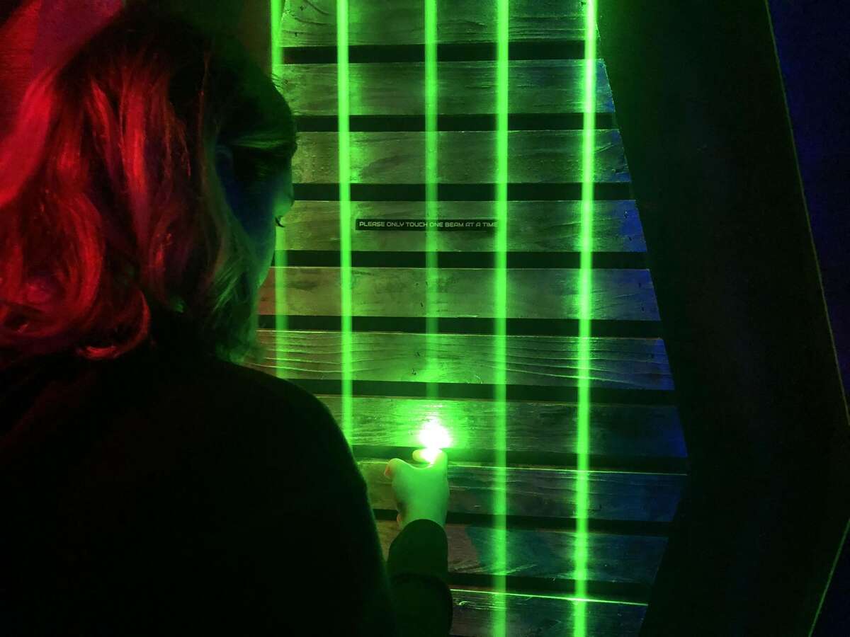 A player at Escape Rooms Connecticut in Orange searches for clues that will get her team out of the escape room.