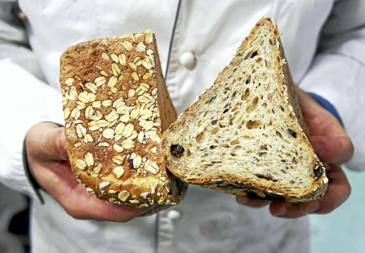 Andrea Corazzini, owner and general manager of Whole G Bakery, holds a cross section of the MuesliBrot.