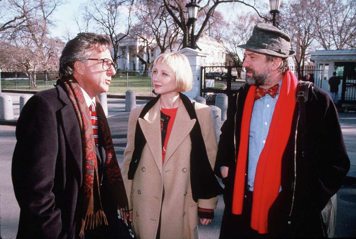 FILE--Dustin Hoffman, left, Anne Heche, center, and Robert DeNiro, right, are shown in character from the movie "Wag The Dog" in this undated file photo. While idling outside the estate where the Clintons were vacationing Thursday, Aug. 20. 1998, in Martha's Vineyard, the White House press pool was viewing the movie "Wag The Dog" when the military strikes against Sudan and Afghanistan got under way. Coincidently, ``Wag the Dog" scripts a foreign crisis to distract attention from the president's sex scandal. (AP Photo/New Line Cinema)