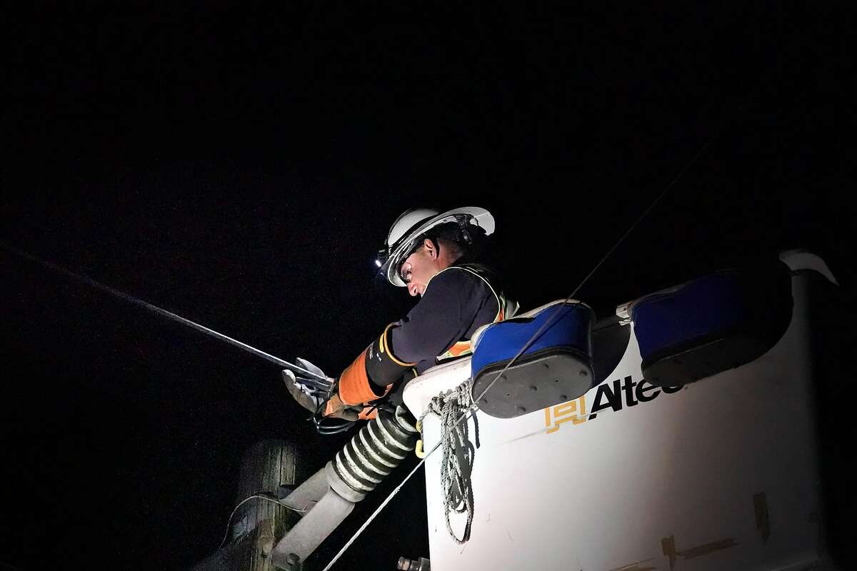A PG&E technician repairs the last of broken power line on Skyline Blvd. before powering it up at 7:30 p.m. on Thursday, Oct. 10, 2019 in Oakland, Calif..