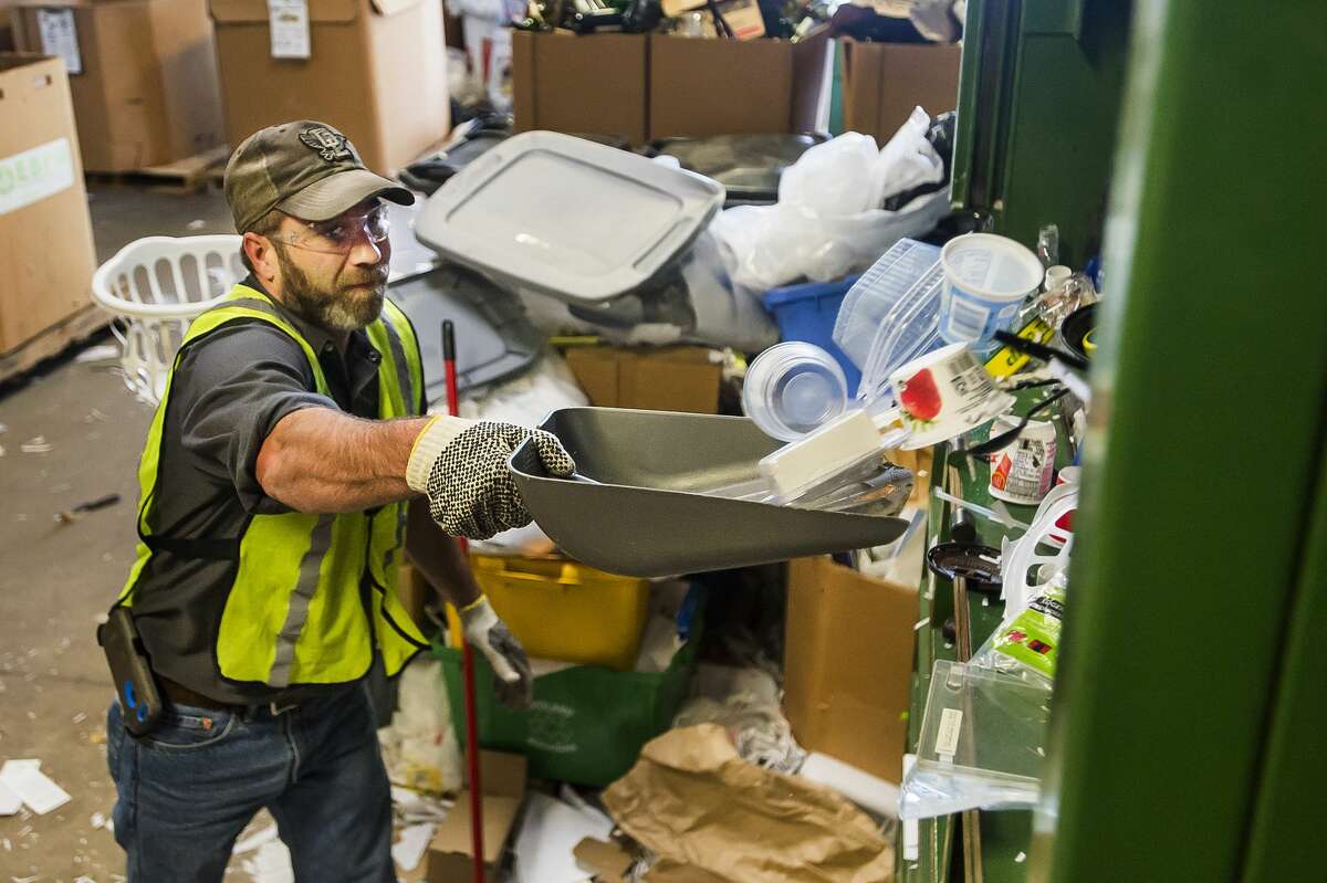 Jason Kempf shovels plastic items into a baler at Midland Recyclers Thursday, Oct. 10, 2019 at the Midland City Landfill. (Katy Kildee/kkildee@mdn.net)