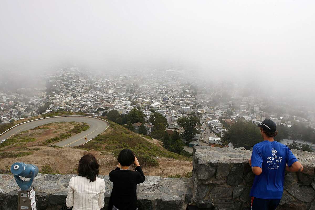 Tourists visiting Twin Peaks in San Francisco, Calif., as fog was drifting through on Friday August 3, 2012.