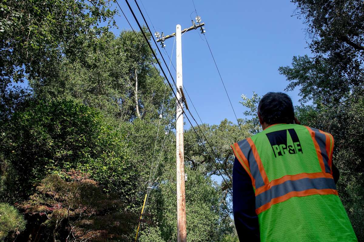 PG&E crew member Rick Bertel inspects a power line with an issue while on the phone with a colleague during a power line damage check along Camellia Lane in Lafayette, Calif. Friday, Oct. 11, 2019 following PG&E Public Safety Power Shutoffs across Northern California.