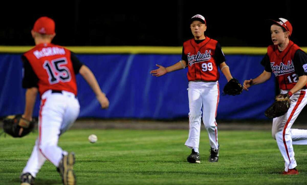 The ball drops in the outfield due to confusion among, from left, Billy McGrath, Chris Howell, and Patrick O'Leary during Fairfield's game against Rhode Island in Bristol on Friday, August 6, 2010.