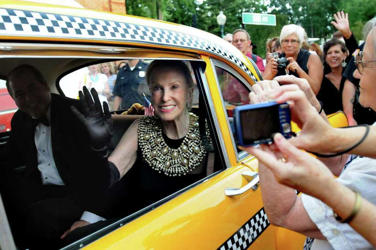 Marylou Whitney, center, waves to her adoring fans as she and husband John Hendrickson, left, arrive in a Taxi for the Whitney Gala at the Canfield Casino on Friday, Aug. 6, 2010, in Saratoga Springs, N.Y. This year's theme is Breakfast at Tiffany's. (Cindy Schultz / Times Union)