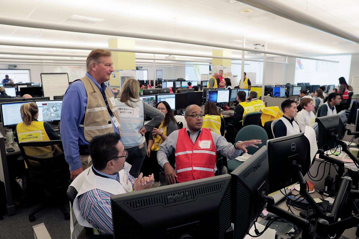 PG&E Communications Representative Mark Mesesan speaks with Raul De Guzman and Kevin Smith at PG&E's Emergency Operations Center in San Francisco, Calif., on Wednesday, October 9, 2019. The utility�s personnel there manage the public safety power shutoffs, which began last night and will continue throughout the day today as the Diablo winds begin to rise.