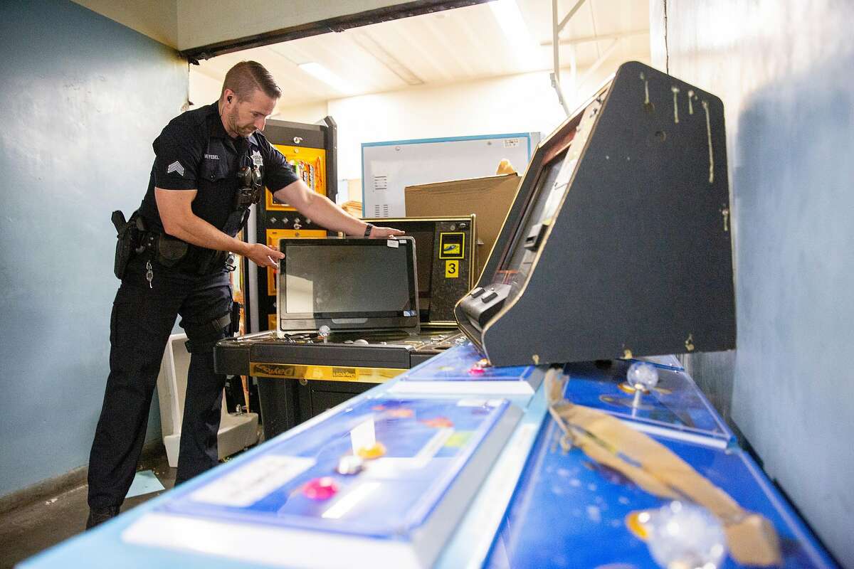 Sgt. William Febel in the evidence room with confiscated gambling devices at the Oakland Police Department on Thursday, July 18, 2019, in Oakland, Calif. In the past year, Oakland police and the city attorney's office have cracked down on illegal, pop-up casinos, aiming to root out the violent crime that often accompanies them.