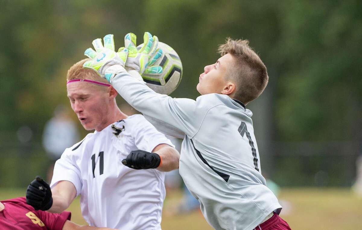 St. Joseph keeper Deaglan Prendergast takes the ball off Trumbull's Justin Horvath's head on Saturday. High school boys soccer action between St. Joseph high school and Trumbull High at St. Joseph, Saturday, Oct. 12.