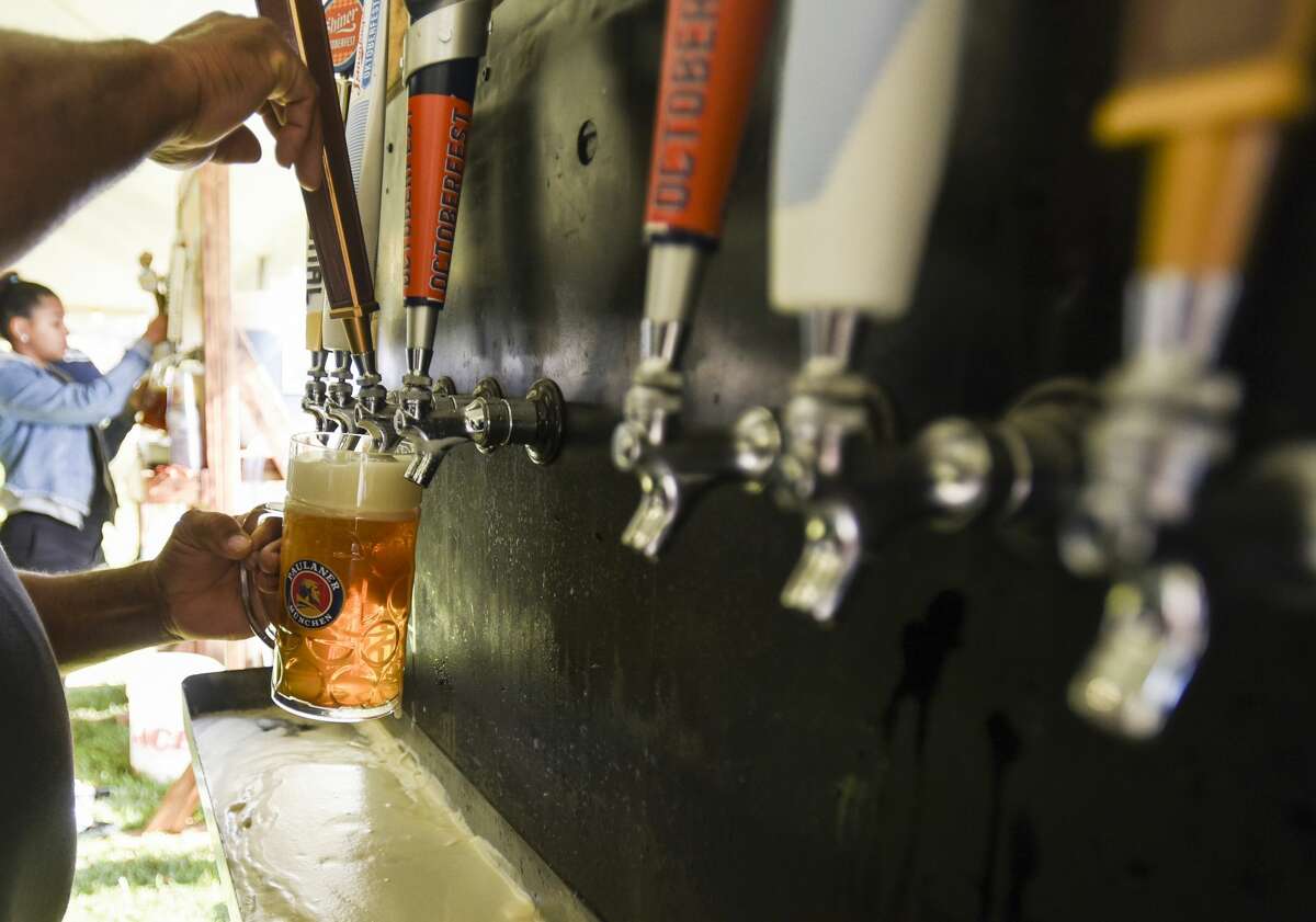 A bar attendant pours a beer out for people enjoying the beer, food and live music at Beaumont's Oktoberfest Saturday afternoon. Photo taken on Saturday, 10/12/19. Ryan Welch/The Enterprise