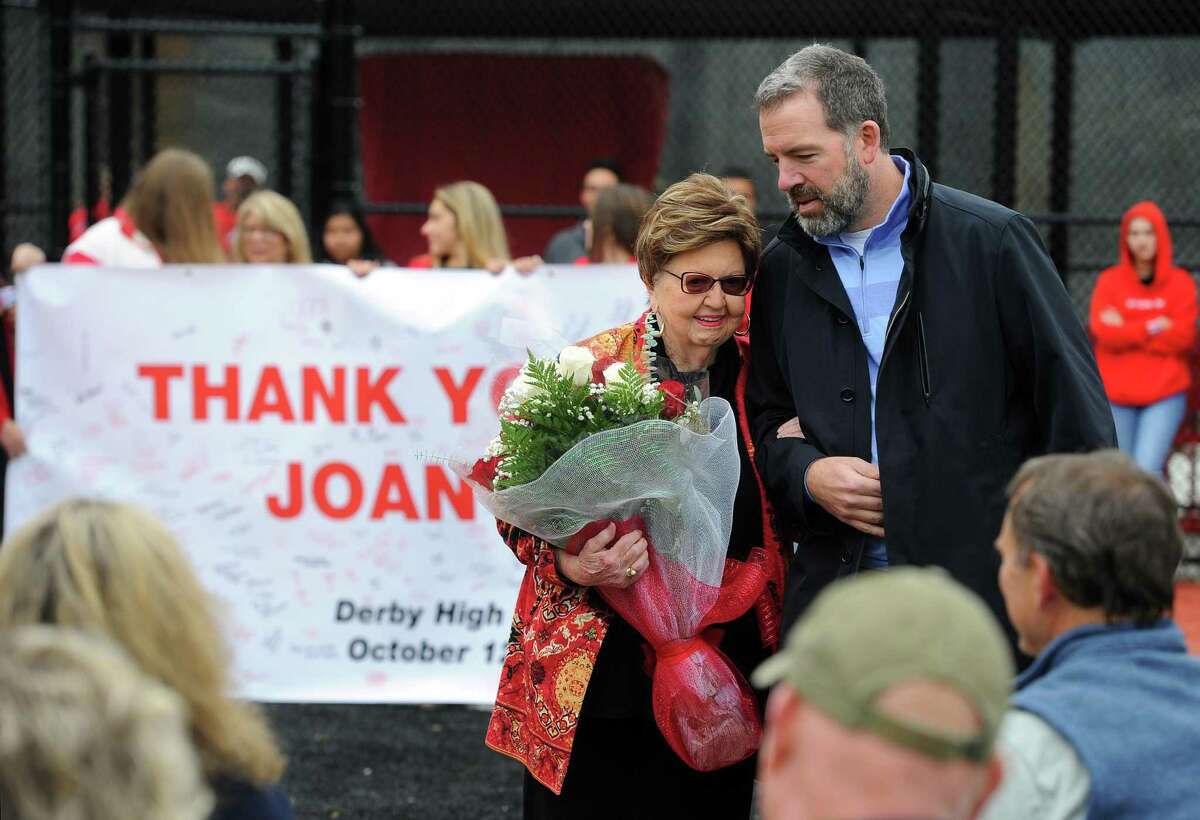 Joan Payden is helped back to her seat by Justin Bullion during the dedication ceremony for the J.R. Payden Field House in Derby, Conn., on Saturday Oct. 12, 2019. Payden donated $23 million for the reconstruction of the Derby High baseball and softball fields as well as the building of the Joseph R. Payden Field House. Her father was the 1915 valedictorian of Derby High.
