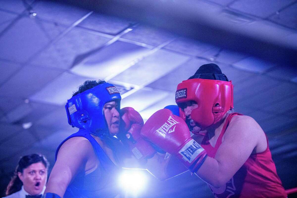 Representing San Antonio firefighters and police officers, Kassandra Hernandez, right, and Alyssa Perez, left, compete Saturday during the fourth annual tournament held by Guns & Hoses Boxing of San Antonio. Hernandez beat Perez by unanimous decision in three rounds. The proceeds from the nonprofit's event will go to organizations that help the families of fallen first responders.