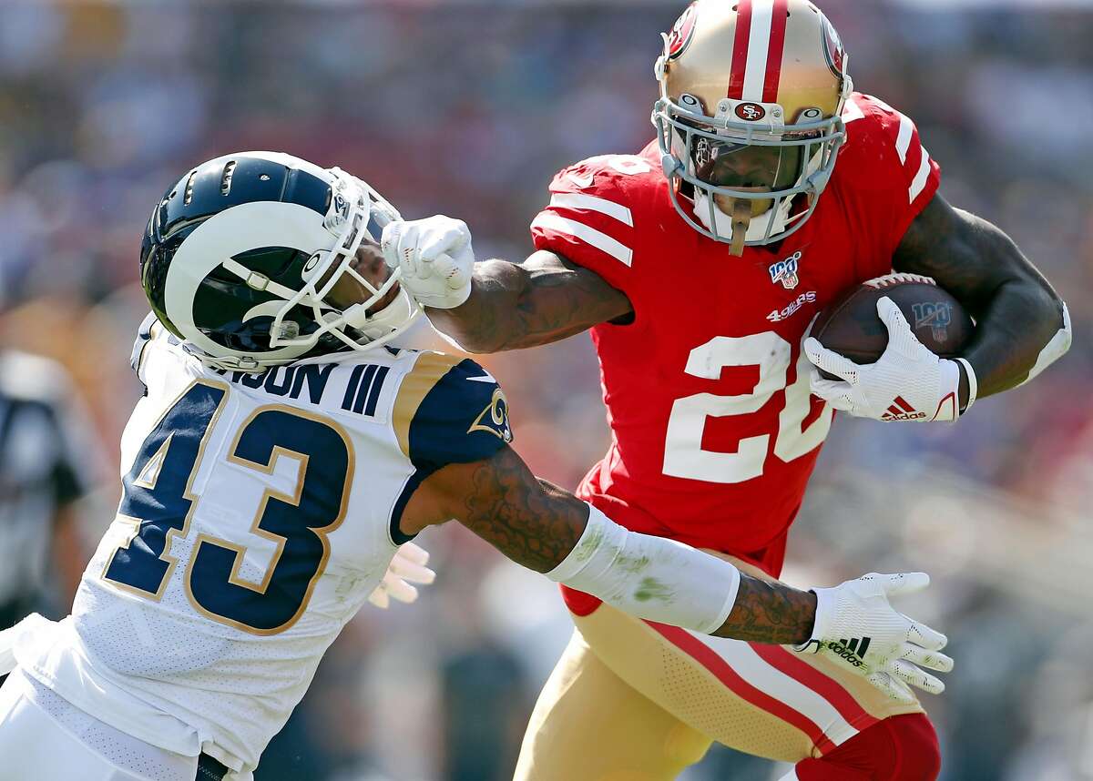San Francisco 49ers' Tevin Coleman stiff arms Los Angeles Rams' John Johnson III during 2nd quarter touchdown run during NFL game at Los Angeles Coliseum in Los Angeles, Calif., on Sunday, October 13, 2019.