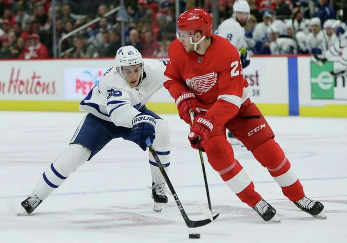 Toronto Maple Leafs right wing Ilya Mikheyev (65), of Russia, tries to steal the puck from Detroit Red Wings defenseman Dennis Cholowski (21), of the Czech Republic, during the first period of an NHL hockey game on Saturday. (AP Photo/Duane Burleson)