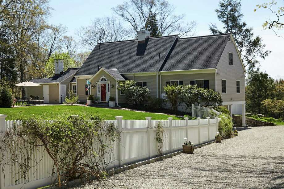 The taupe-colored Cape Cod colonial house at 5 River Road sits on a nearly four-acre property in Lower Weston.