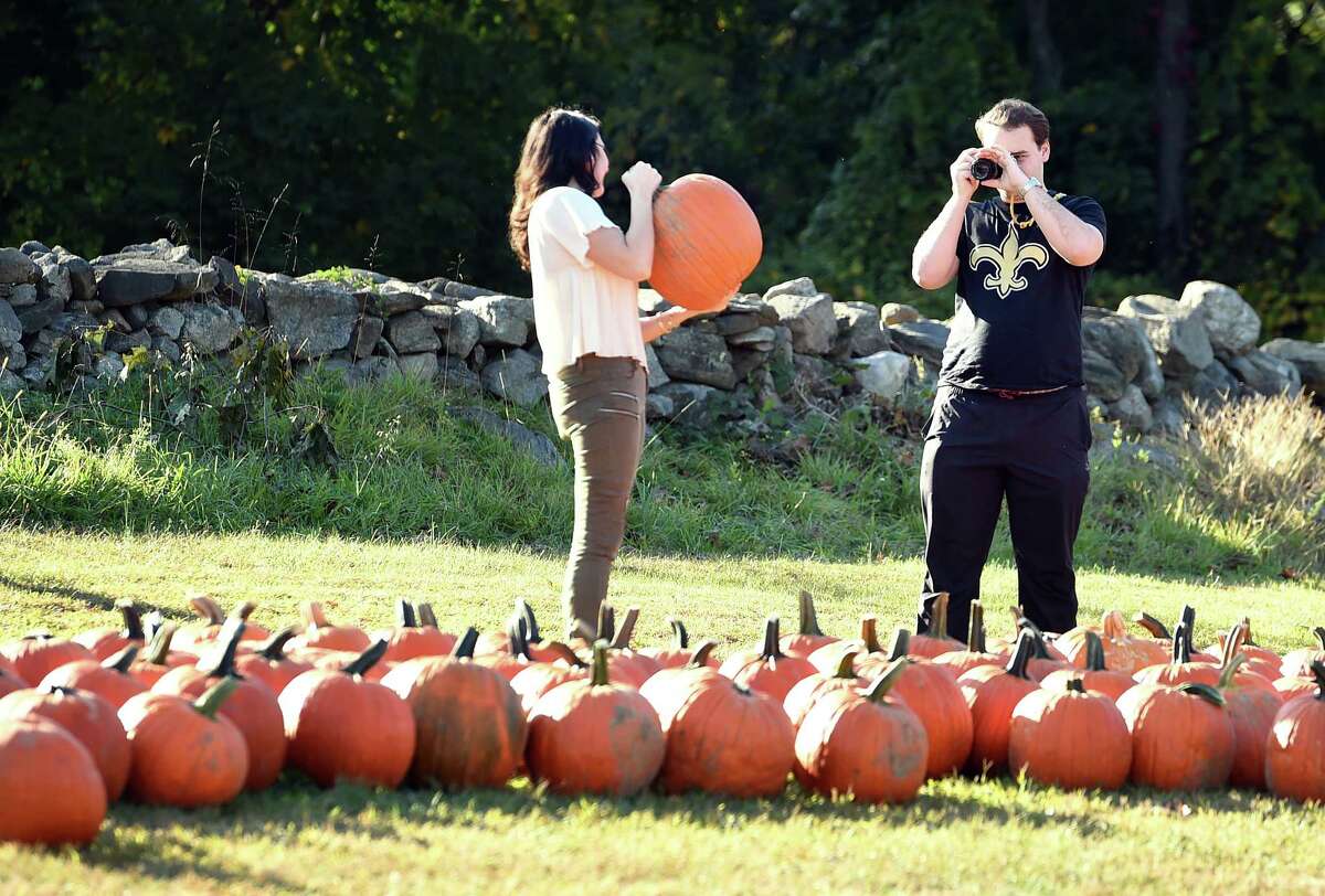 Monica Traniello (left) of New York City has her photograph taken by her boyfriend, Hugh Perkins, of New Haven while picking out pumpkins at Bishop's Orchards Farm Market & Winery in Guilford on October 14, 2019.