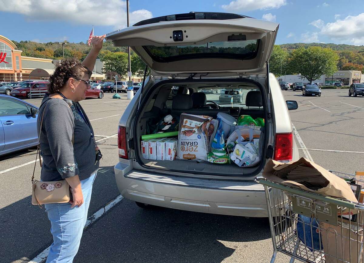 Tracey DeLibero of Ansonia shuts the trunk of her packed car after a second trip to Big Y in Ansonia, Conn. on Monday Oct. 14, 2019.