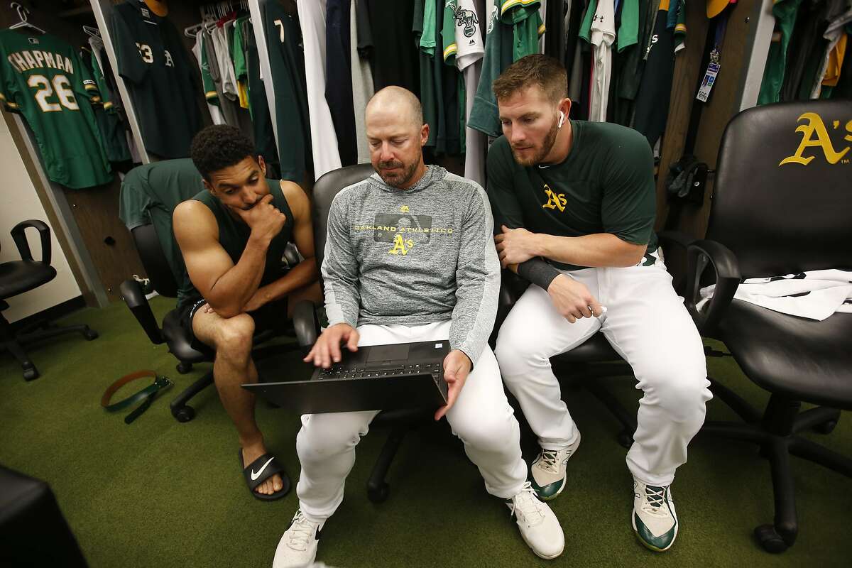 OAKLAND, CA - JULY 30: Marcus Semien #10, Bench Coach Ryan Christenson #29 and Robbie Grossman #8 of the Oakland Athletics watch videos in the clubhouse prior to the game against the Milwaukee Brewers at the Oakland-Alameda County Coliseum on July 30, 201