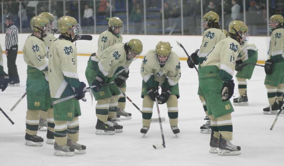 Notre Dame hockey players stand dejectedly after a Hamden goal in the Green Knights’ 4-3 loss last Wednesday at the Edward L. Bennett Rink in West Haven. With the loss, Notre Dame finished with a 7-12-1 record and failed to qualify for the state tournament for the first time in 19 years. The Green Knights closed the season with eight straight losses. (Photo by Russ McCreven)