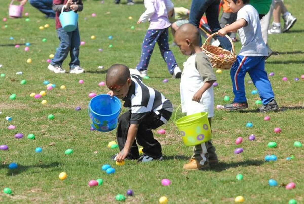 Photo by Joseph Cole Aisalin Washington and Quinton Hebron scramble for brightly-colored eggs spread out acrosss a section of lawn at Town Center Park at Meadowbrook.