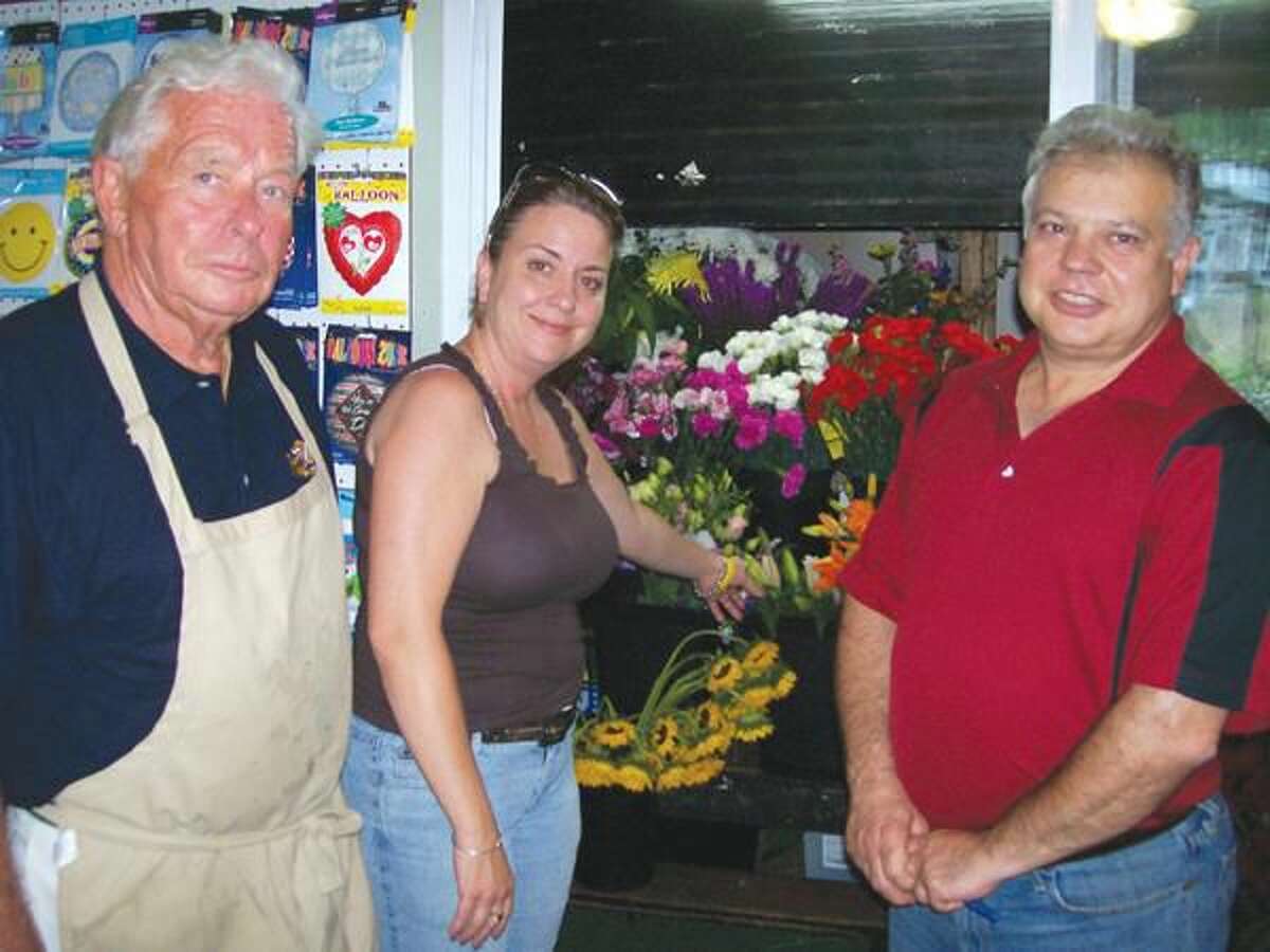Photo by Lynn Fredricksen Gerry Pfeiffer, left, and Karen Morgan with Forget Me Not owner Luigi Nuzzolillo at the cooler containing numerous varieties of colorful flowers.