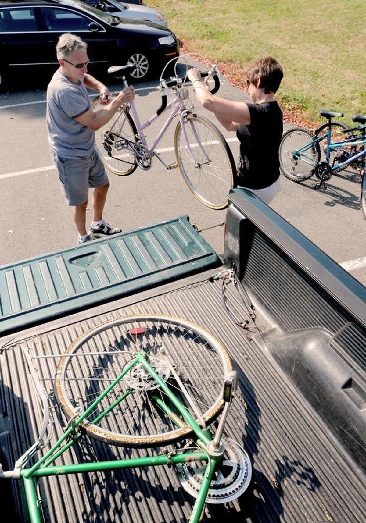 Photo by Peter Hvizdak Jerry, left, and Pat Roy of Hamden, unload one of three bicycles for the Connecticut Bike Project collection at Mt. Carmel Parish in Hamden.