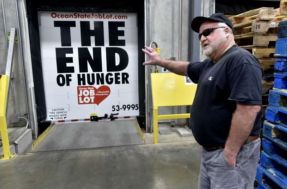 Mike Desmarais, a truck driver for Ocean State Job Lot, shows off the anti-hunger campaign slogan paint job on the back of his semi-tractor trailer truck Wednesday after he just delivered food packaged in bulk to the Connecticut Food Bank warehouse in Wallingford.