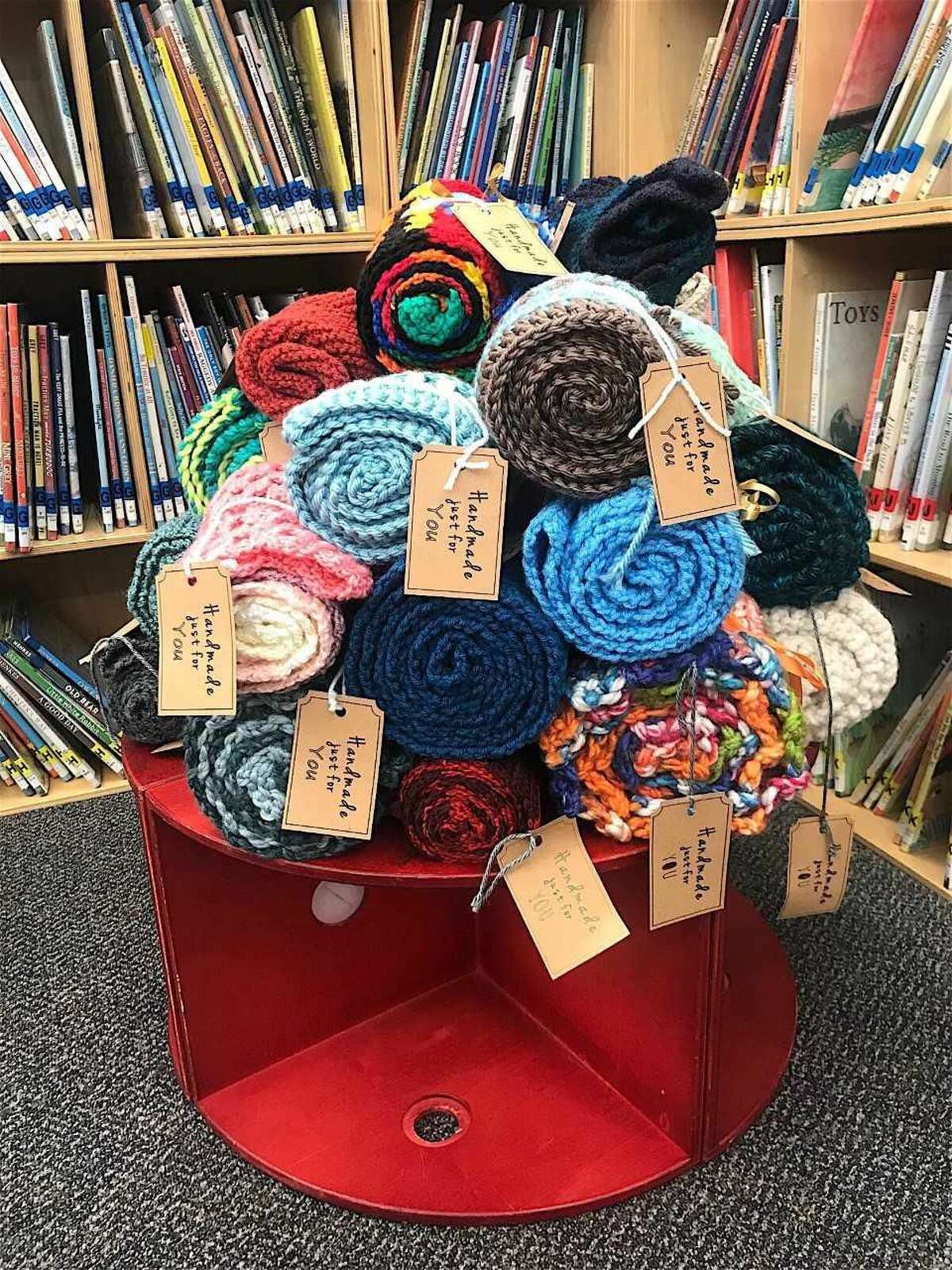 Knitted creations at Hamden Library with cards saying, "Handmade just for you."