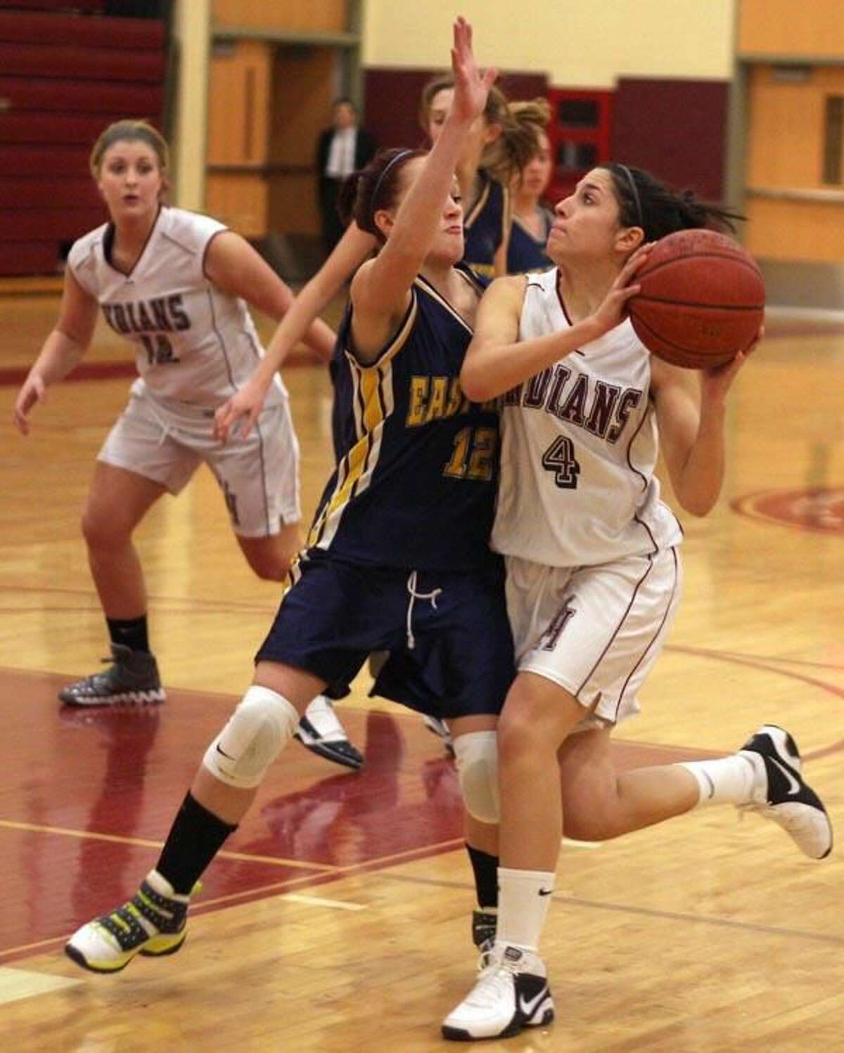 Photo by Russ McCreven North Haven's Olivia DiCapua looks to shoot while East Haven's Julie Waters defends in the Indians’ 39-28 victory.