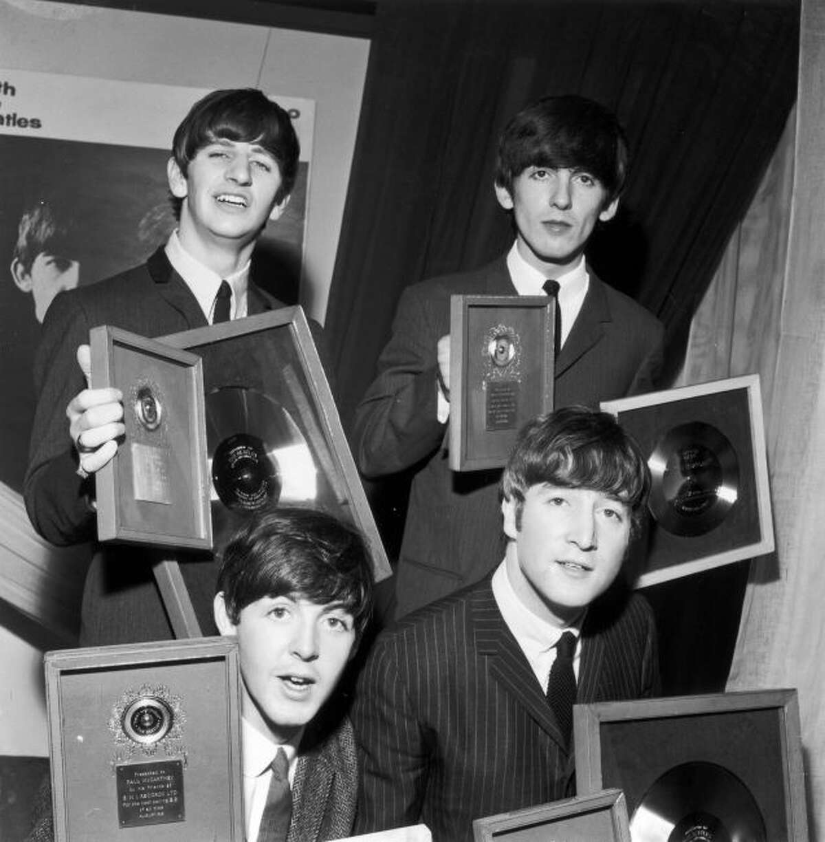 The Beatles holding their silver LP and EP discs presented to them by EMI records in London to mark sales of records including the LP “Please Please Me” and “Twist And Shout,” the best-selling EP of all time. Clockwise from back left: Ringo Starr, George Harrison, John Lennon and Paul McCartney.