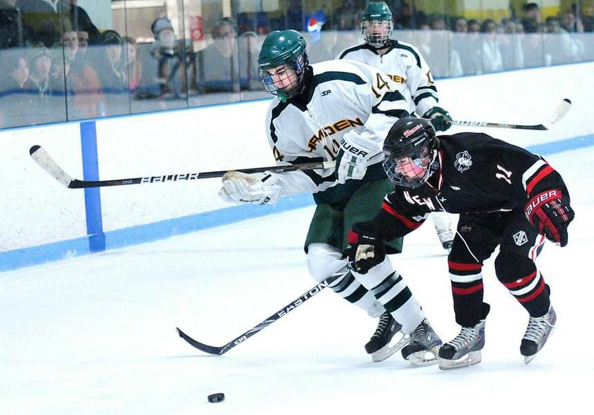 Photo by Peter Casolino/ Register Hamden's Zak Masotta battles for the puck with New Canaan's Charlie Corcoran during the second period.
