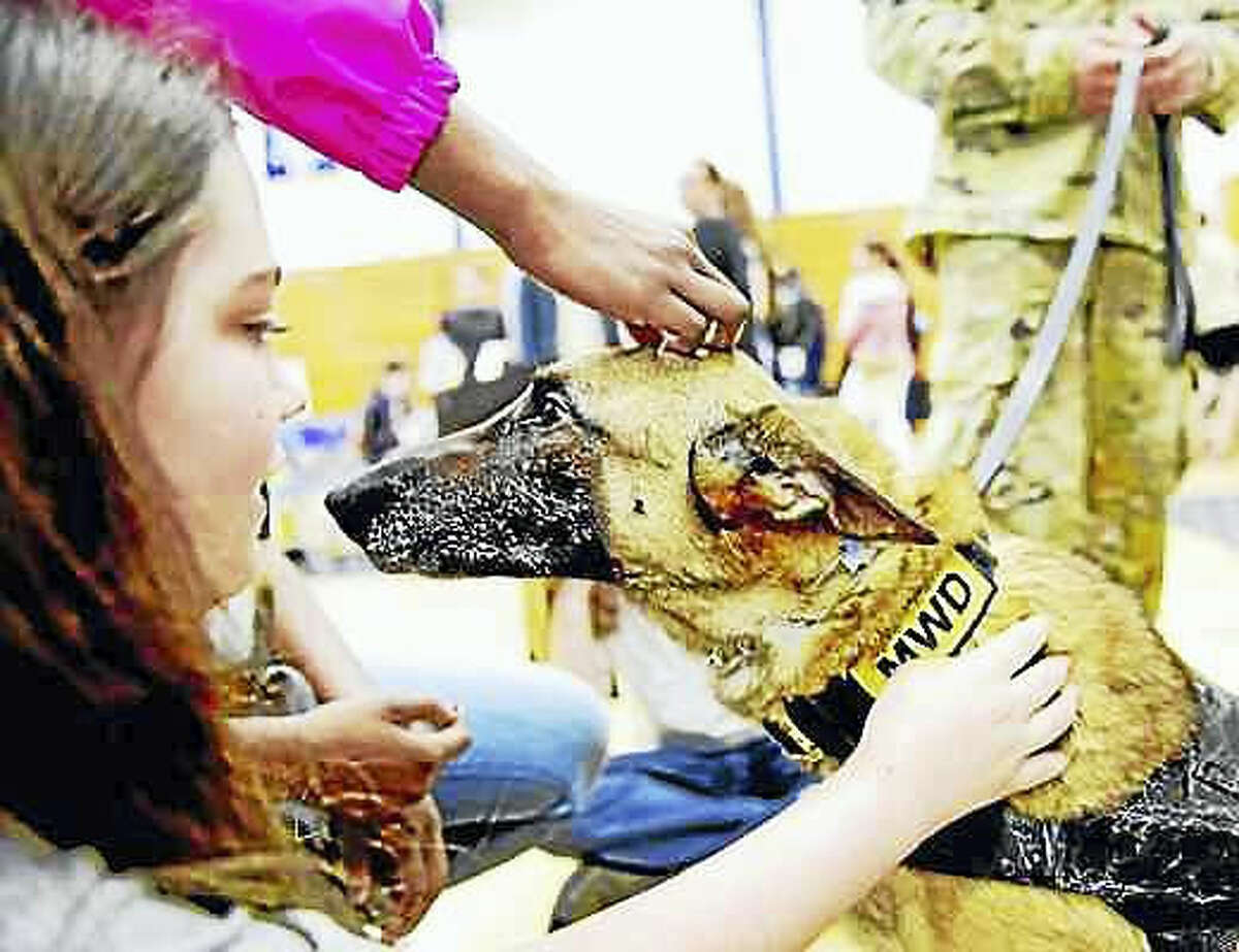 Peter Hvizdak — New Haven Register.  Melissa Pope of Hamden, 13, left, pets U.S. Army Military Working Dog Balou, a Belgian Malinois handled by Army Sgt. Christopher Rufini during the town’s Veterans Awareness Day, sponsored by the Hamden Veterans Commission Wednesday at Quinnipiac University.