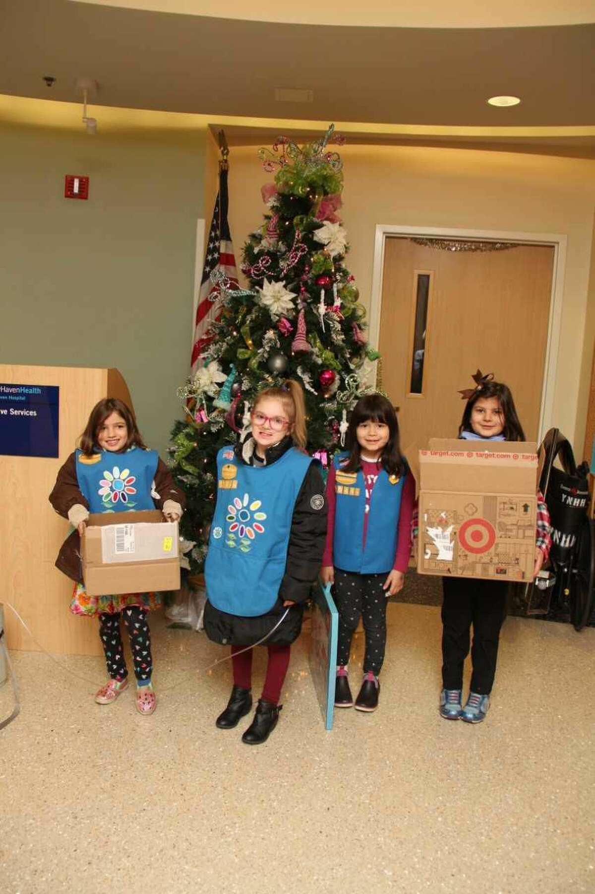 Girl Scouts Evelyn, Daniella, Avery, and Lily with some of the donated toys.