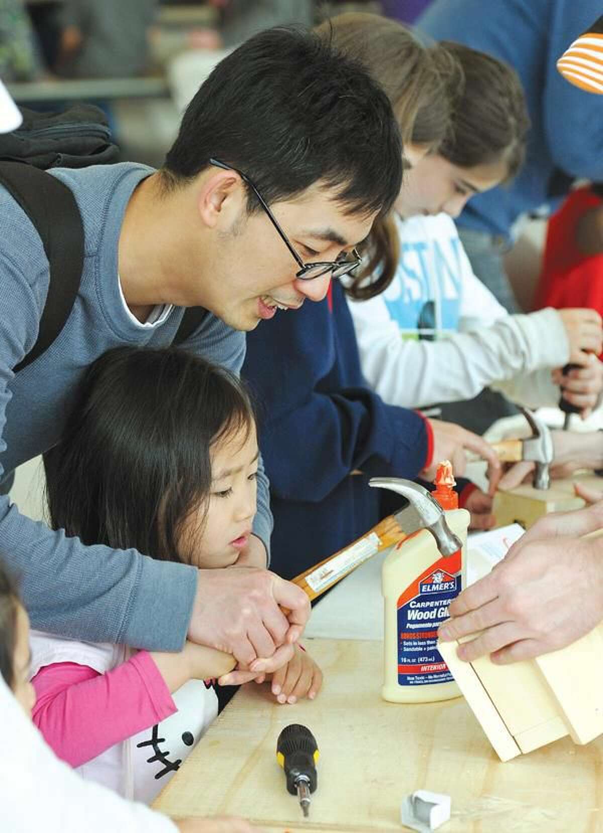 Photo by Peter Casolino 4-Year-old Vivian Niu gets a hand from her father, Heng Yao Niu as they build a birdhouse at the Hamden Earth Day Celebration at Hamden Middle School.