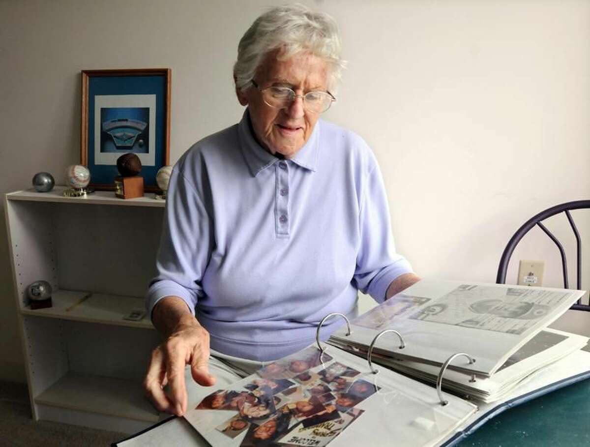Photo by Mara Lavitt/Register Jean Kaas looks through a scrapbook of the baseball minor league players who she hosted while living in West Haven.