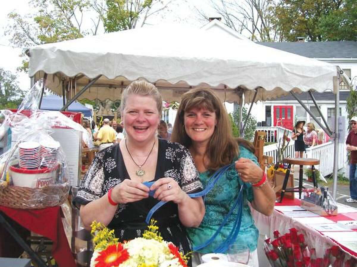 Photo by Lynn Fredricksen Rotarians Susan Pace and Claudia Giulietti enjoyed a few laughs as they manned the raffle booth at the North Haven Rotary Club's 10th Annual Day of Wine & Roses fundraiser held Sunday at Forget Me Not Florist on State Street.