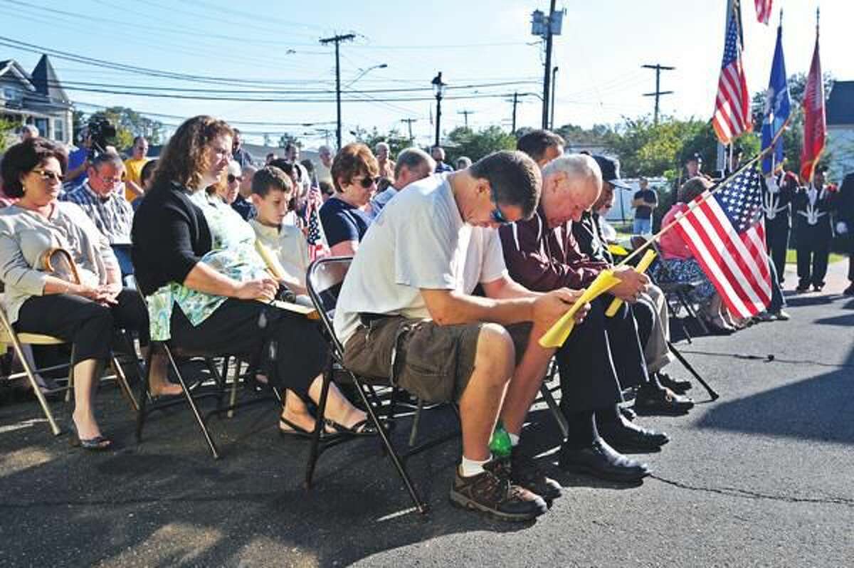 Photo by Peter Casolino People bow their heads in prayer, including Dana Andrews, front, during a 9/11 remembrance ceremony at the North Haven Fire headquarters. During the ceremony, the department honored 20 North Haven firefighters that responded to ground zero to help out in the recovery effort on 9/11 and the days that followed. Andrews is from North Haven.