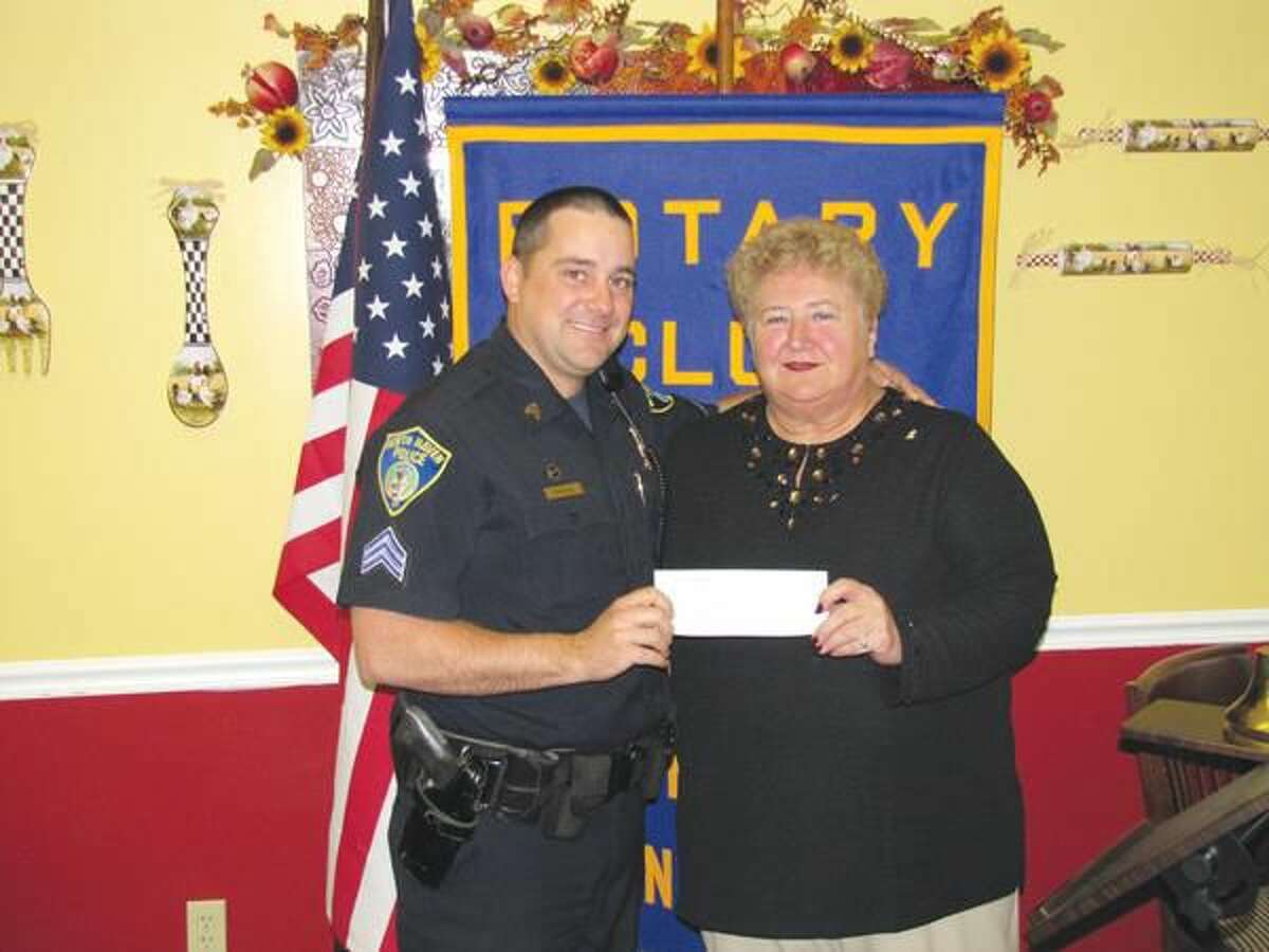 Submitted photo courtesy of David Marchesseault, Rotary PR Chairman North Haven Police Sergeant Christopher Thorpe accepts the annual contribution for D.A.R.E. from Rotarian Mary Jane Mulligan.
