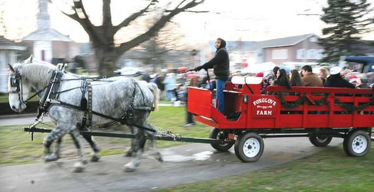 Photo by Peter Casolino Dom Spear of Foxglove Farm (Lyme, CT) drives a horse-drawn carriage around the North Haven Green during the North Haven tree lighting ceremonies Sunday.