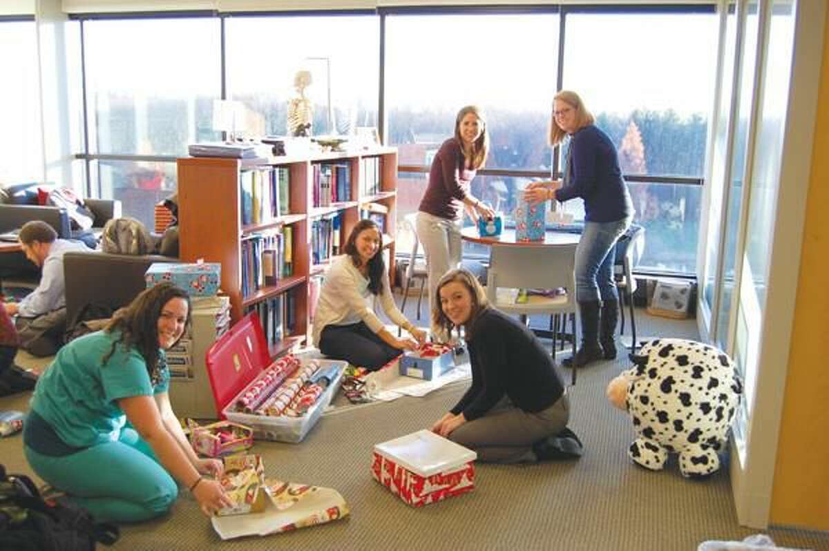 Submitted Photo Quinnipiac University physician assistant students Emma Banks, left, Madeline Santiago, Stephanie Lenihan, Sarah Normandin and Jessie Dorne wrap shoe boxes as part of Operation Christmas Child.