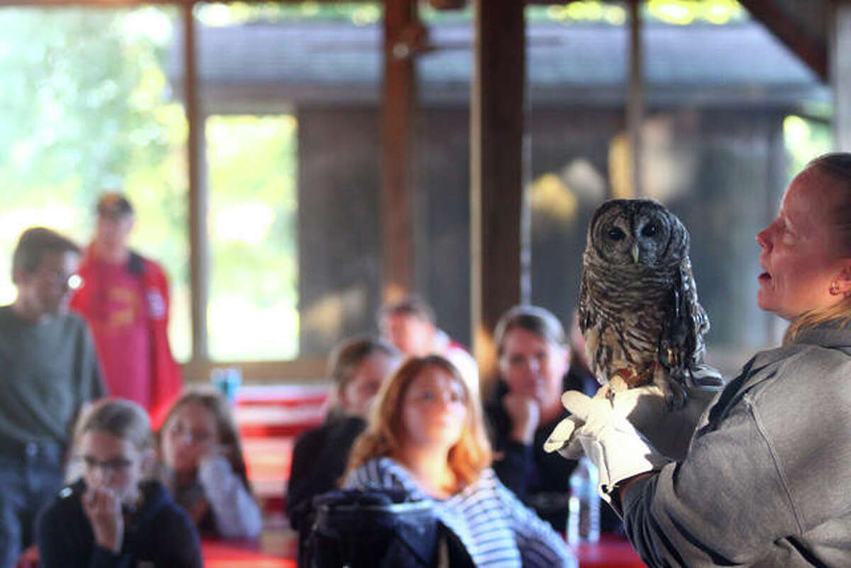 Kelly Vandersand, fundraising coordinator for TreeHouse Wildlife Center, speaks to the Neighborhood Guys and Gals 4-H Club on Monday — while Chili the barred owl patiently sits on her hand.