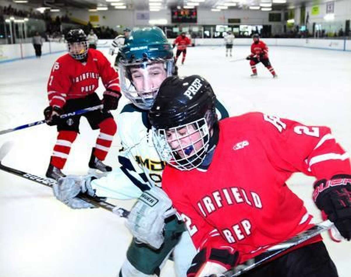 Bill Reilly (center) of Hamden slams Andrew Hatton (center right) of Fairfield Prep into the boards in the first period on 12/25/2012. Photo by Arnold Gold/New Haven Register