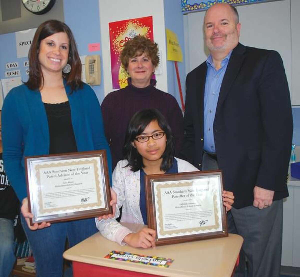 Submitted photo by Adam Bartocetti, Helen Street School Gabrielle Sukmono, seated, a Helen Street School sixth grader, has been named AAA Southern New England’s School Patroller of the Year. The patrol advisor, Lisa Meyer, standing at left, has also been named AAA’s School Advisor of the Year. Fran Mayko, AAA Public Affairs Manager, center, presented plaques to Ms. Meyer and Ms. Sukmono during an informal ceremony at the 285 Helen Street School. At right is Principal Michael Lorenzo.