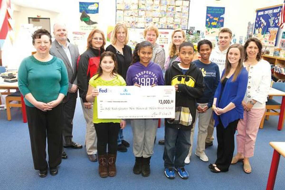 Submitted Photo FedEx presents $3,000 to Safe Kids Greater New Haven and Helen Street School in Hamden. From left: Mary Ann Zavorskas, co-leader of Safe Kids Greater New Haven; Michael Lorenzo, Helen Street School principal; Lisa Bissell of FedEx; Alyssa Alfano; Katie Connors, Helen Street School resource teacher; Evelyn Vidro, Superintendent of Schools Fran Rabinowitz; Karen Gallo, director of Safe Kids CT, Dylan Wrice, Shannon Payne, Thomas Hacku, Kristine Powers, Tracy Van Oss, clinical assistant professor of occupational therapy at Quinnipiac.